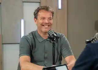 Jurjen Groeneveld Customs Consultant in groene polo in opnamestudio voor de podcast.
